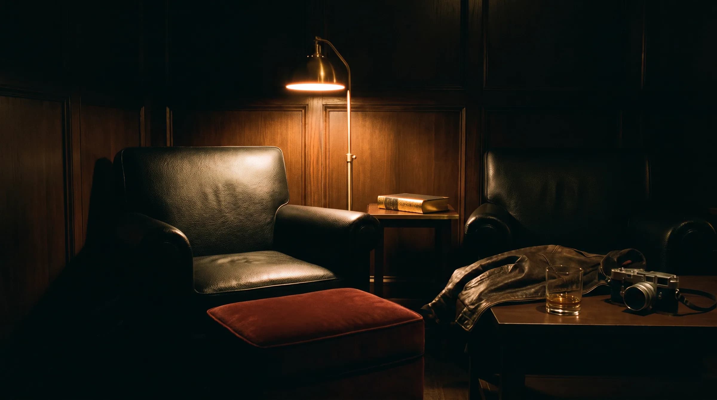 The leather armchair empty under a reading lamp