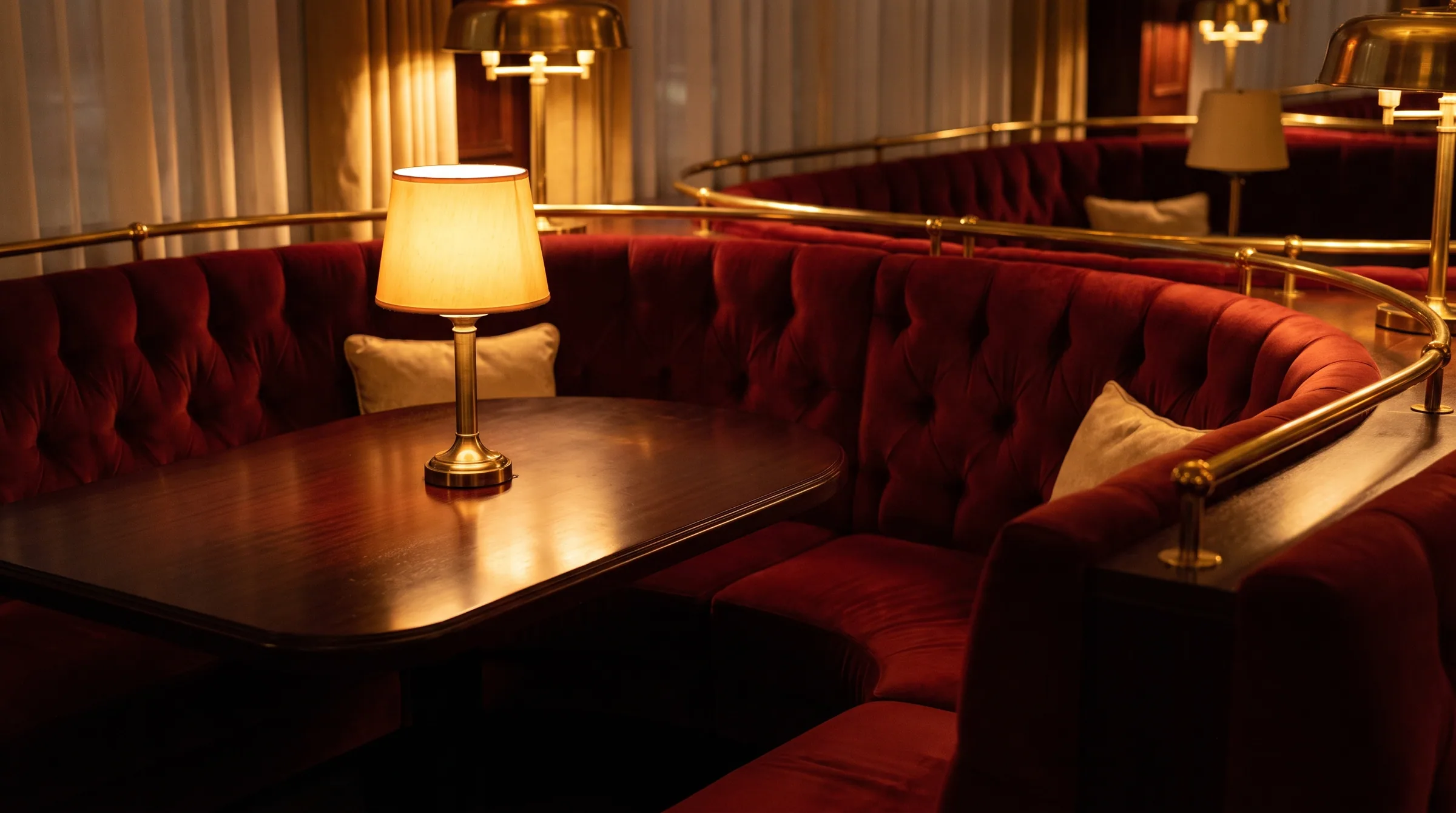 An empty curved booth with the lamp still lit