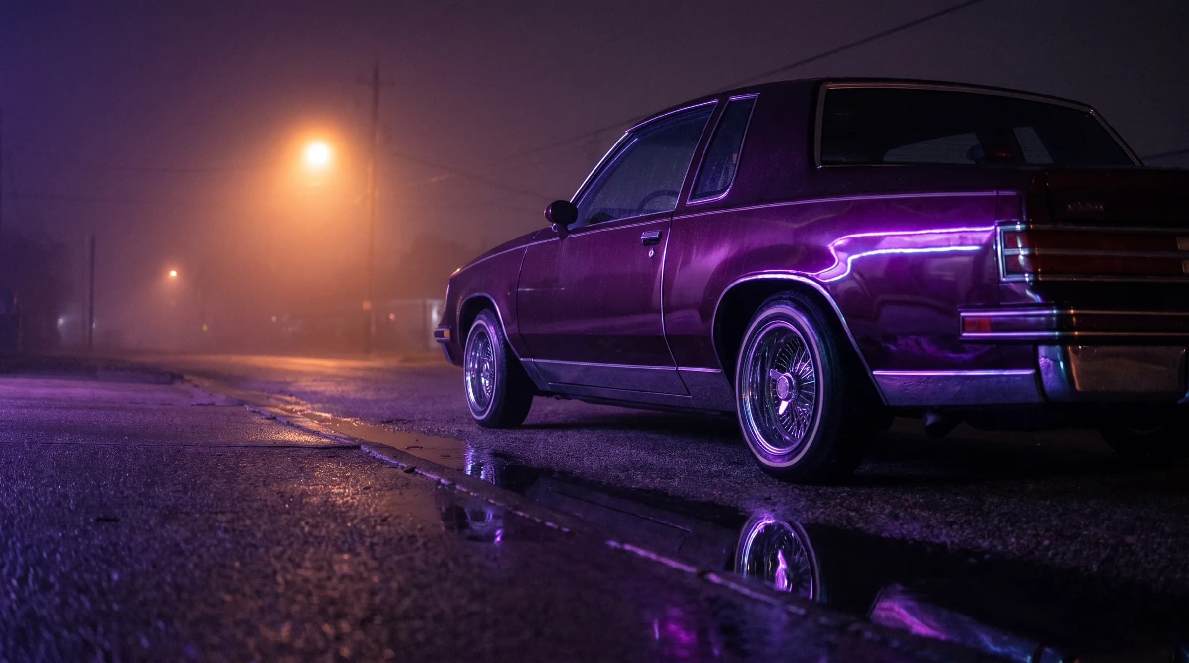 A candy-purple lowrider parked at the kerb in fog under a streetlight